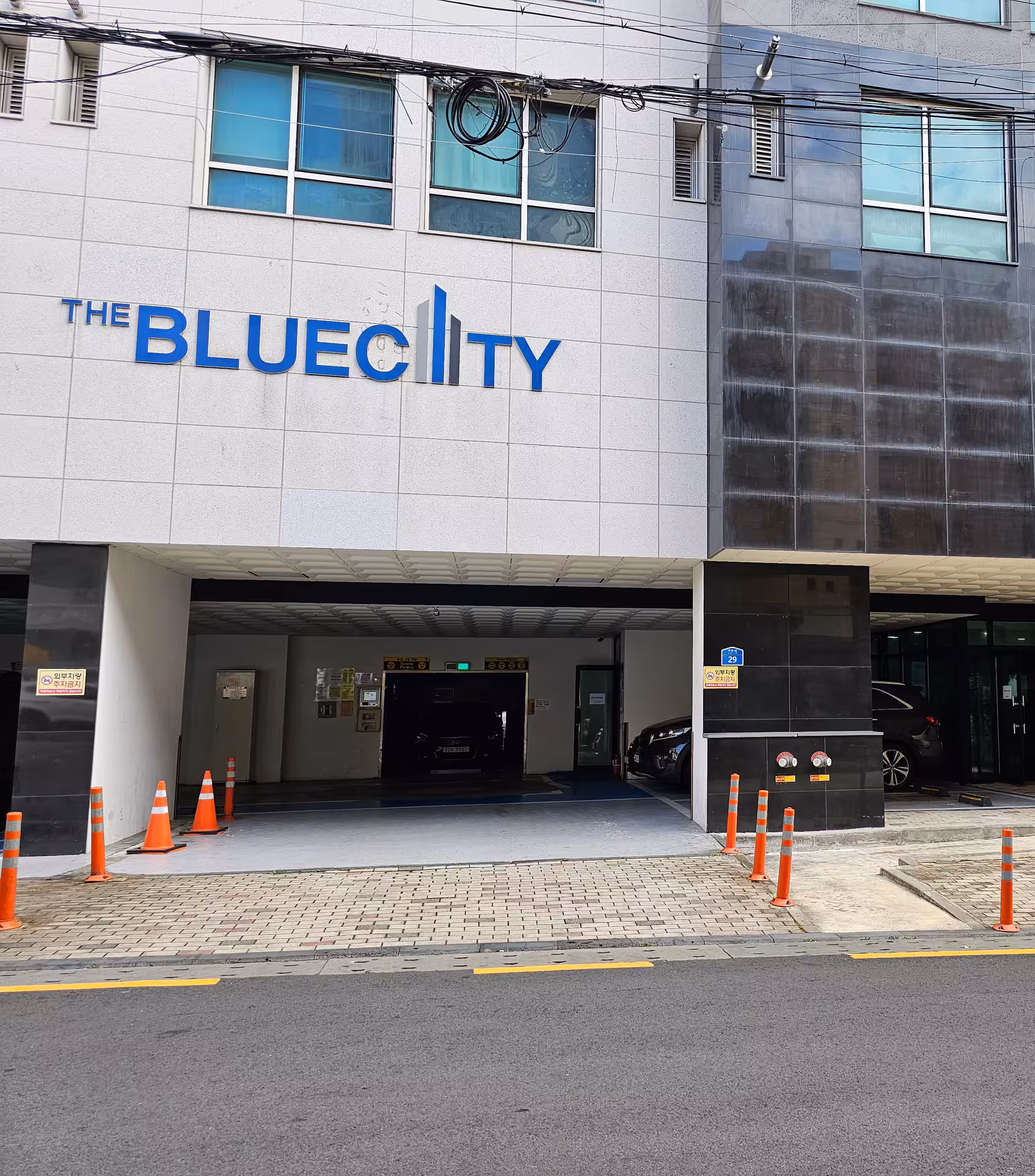 THE BLUECITY 간판과 주차장 입구가 보이는 건물 1층